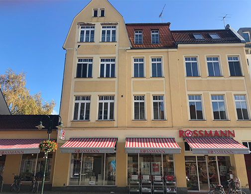 Wohn- und Gewerbeimmobilie in Strausberg, gelbe Fassade und große Schaufester im Erdgeschoss