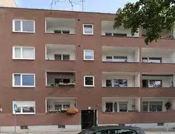 Mehrfamilienhaus in Berlin-Spandau, braune Außenfassade mit Balkonen