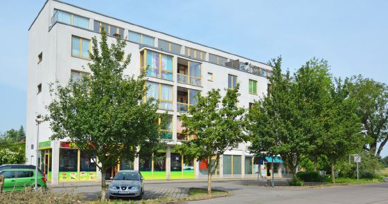 Wohn- und Geschäftshaus in Velten, weiße Fassade mit Gewerbeeinheiten im Erdgeschoss