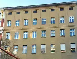 Mehrfamilienhaus in Berlin-Mitte, dunkle Außenfassade, viele Fenster