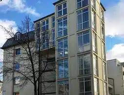 Wohn- und Geschäftshaus in Berlin-Reinickendorf, viele Fenster, hoher Turm
