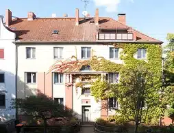 Mehrfamilienhaus in Berlin-Reinickendorf, helle Fassade mit Efeu bewachsen