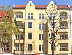 Wohn- und Geschäftshaus in Charlottenburg-Wilmersdorf, gelbe Außenfassade mit Balkonen