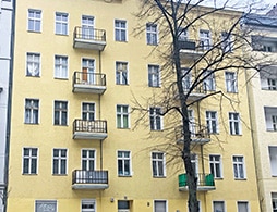 Wohnhaus in Berlin-Neukölln, gelbe Außenfassade mit Balkonen